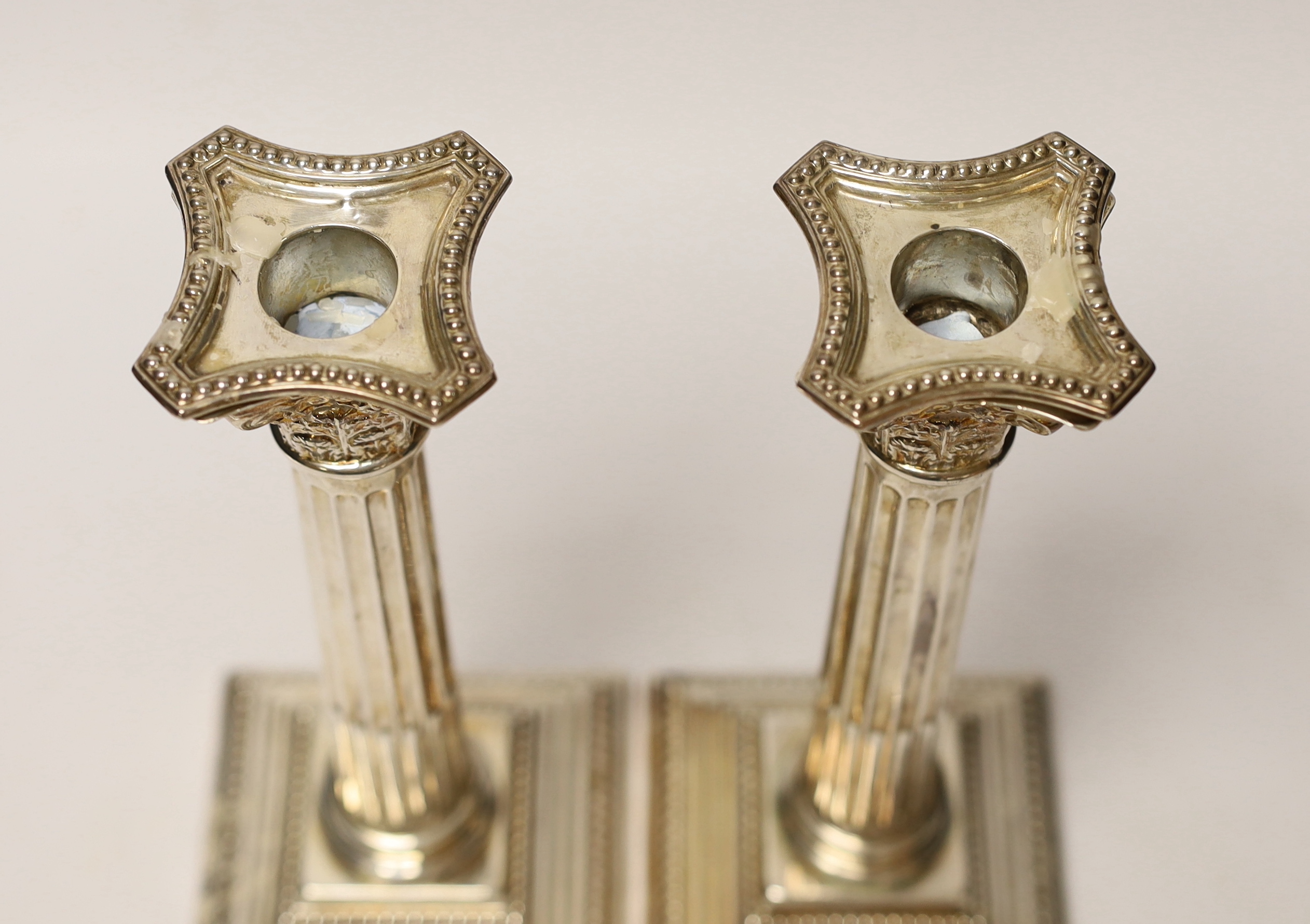 A pair of Elizabeth II silver Corinthian column candlesticks, Hampton Utilities, Birmingham, 1960, 24.3cm, weighted.